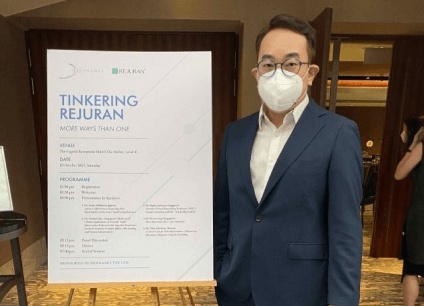 dr kim standing beside a poster