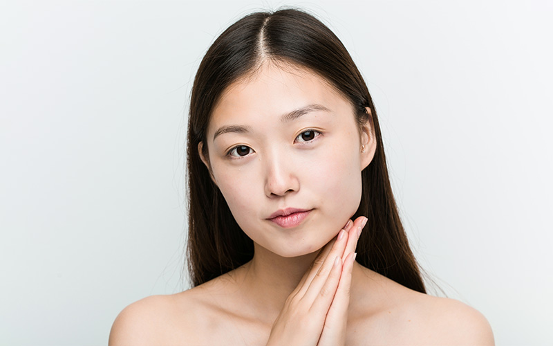 A close-up of a smiling woman with clear, healthy skin and high skin density