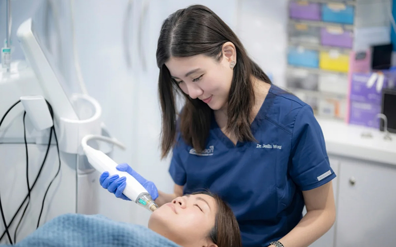  Doctor performing a skin treatment on a patient's face.