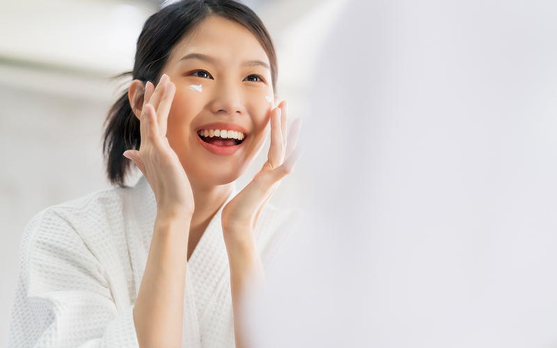 Woman applying collagen skin treatment cream to her face.